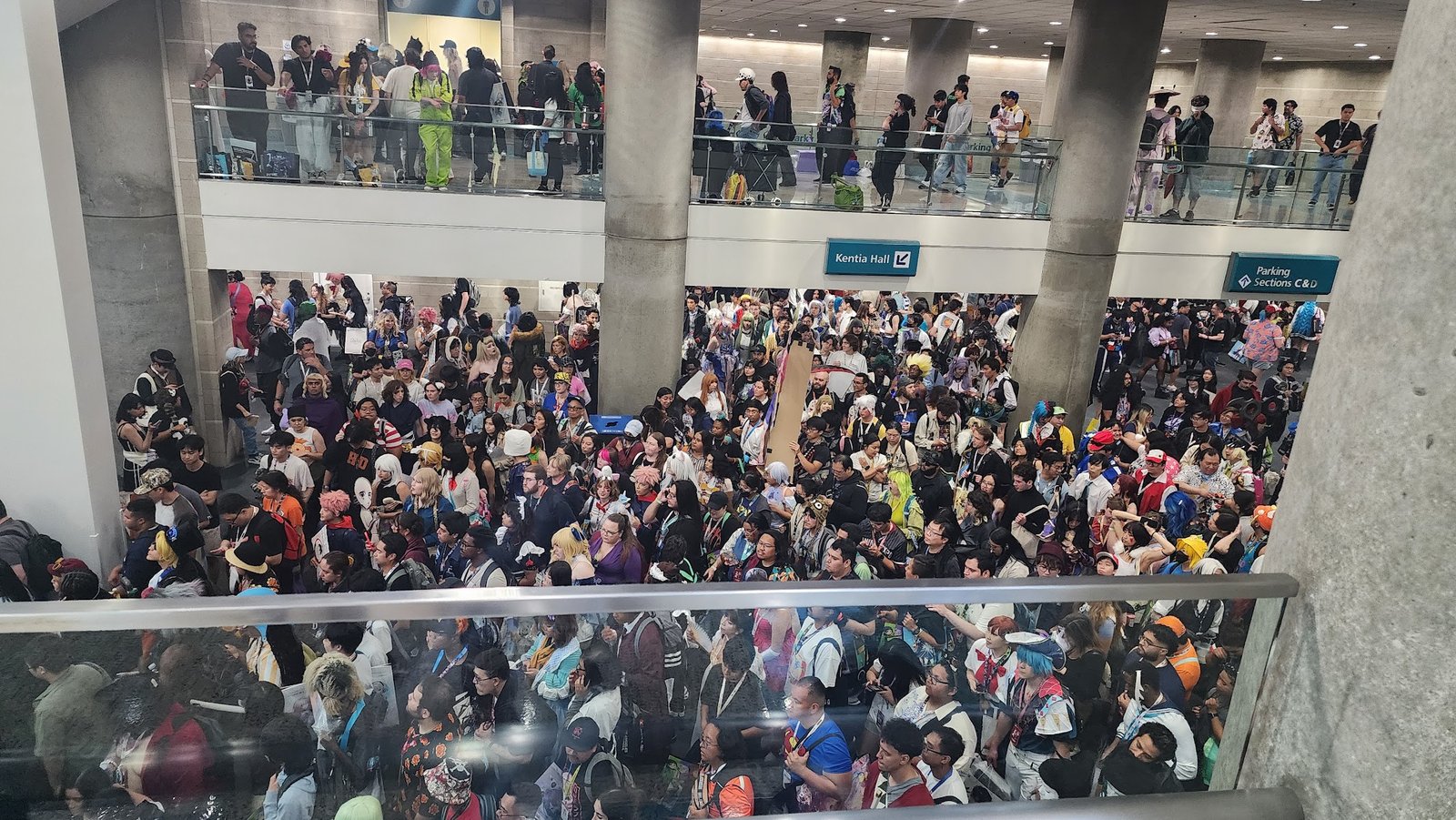 A busy crowd of people trying to slowly make their way through a convention center.